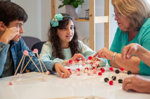 Grandmother playing educational games with grandchildren indoors, fostering creativity and learning.